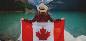 Canadian flag draped over girl at the lake.